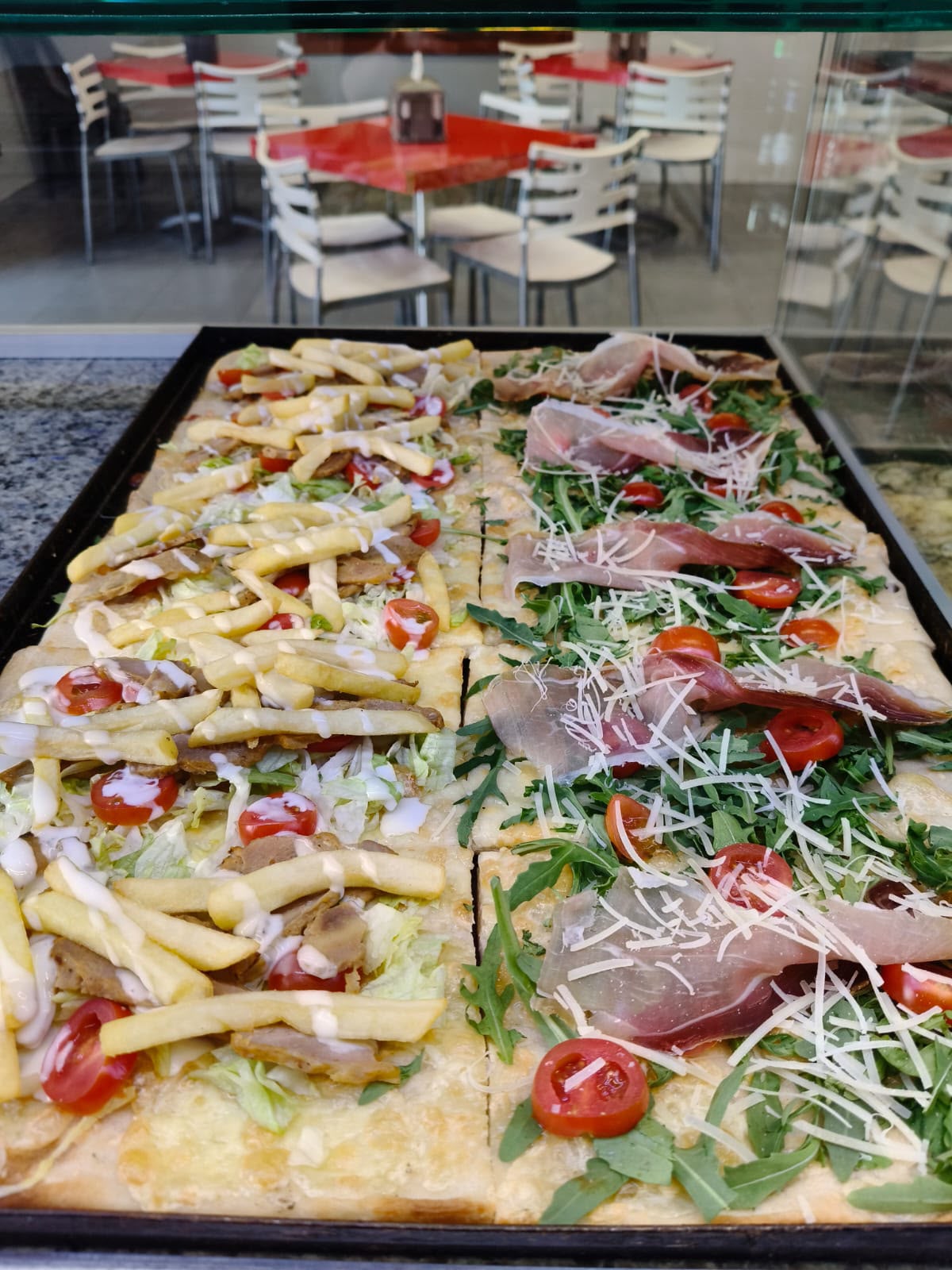 Pizza al taglio con patatine e condimenti